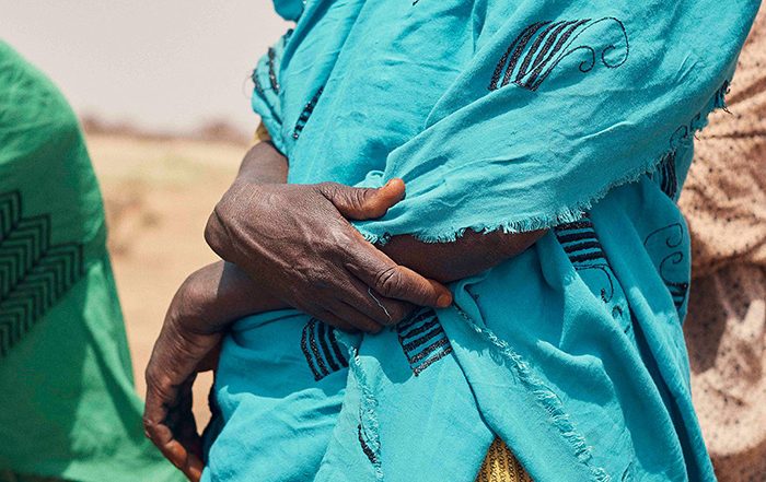 Person wearing blue top holding their arm